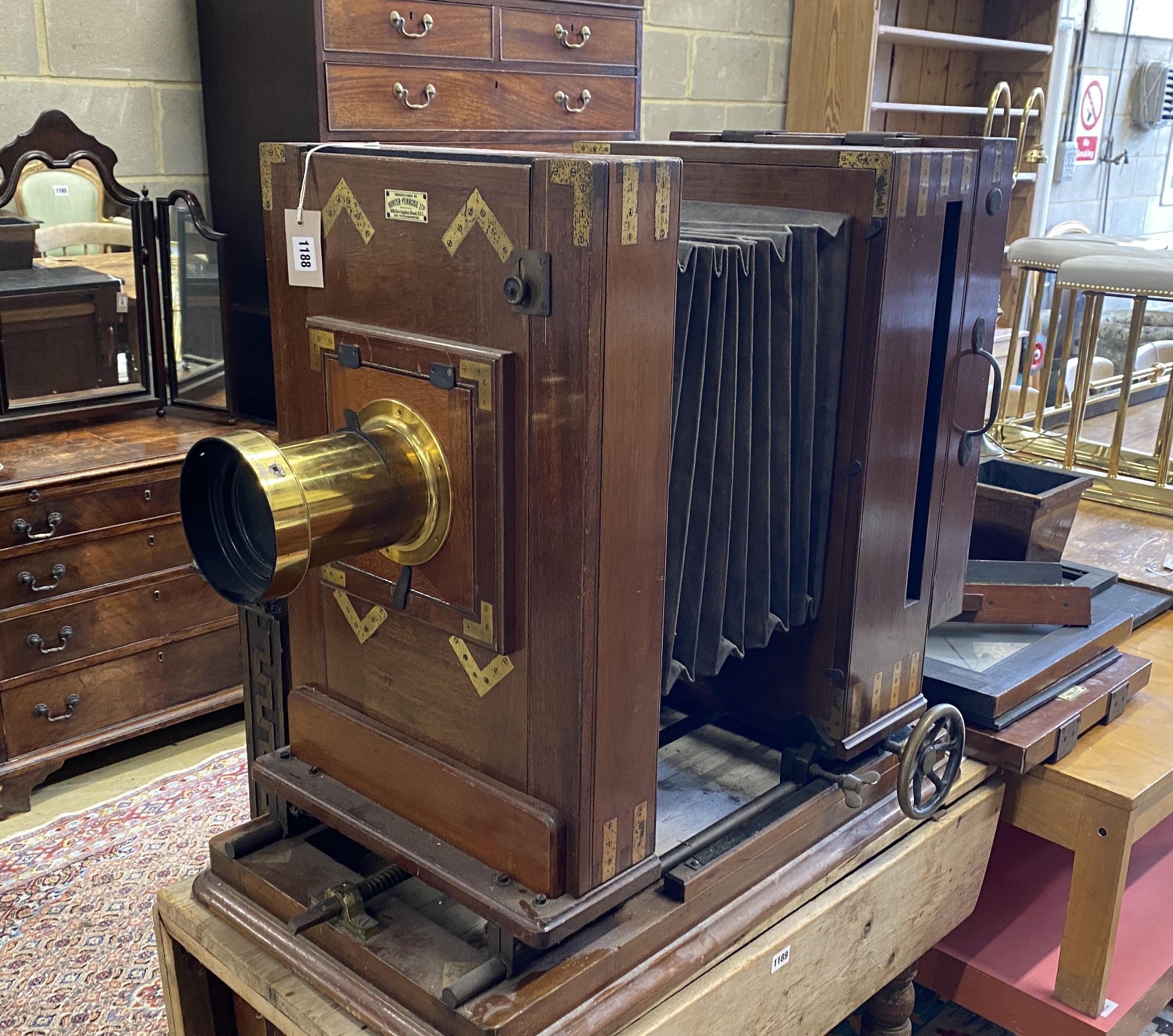 An early 20th century Hunter-Penrose Ltd. brass mounted mahogany studio plate camera, with 4in. lens, height 78cm, width 49cm